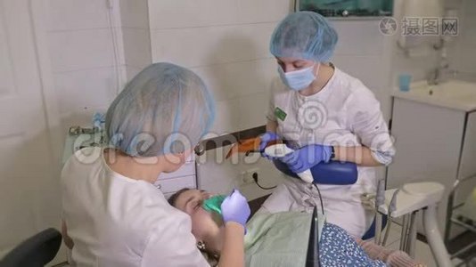牙医诊所的妇女得到牙科治疗，以填补牙齿的空洞。 牙科修复和复合材料视频