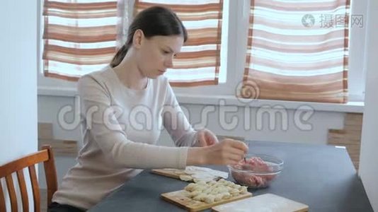 女人用肉馅包饺子。视频