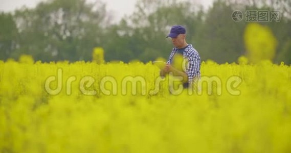 用数字平板电脑查看田间花开的农民视频