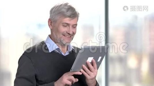 微笑成熟的人使用数字平板电脑。视频