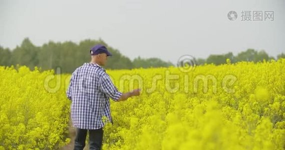 用数字平板电脑查看田间花开的农民视频