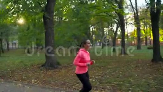 日落时分，一个女人在秋天的公园里奔跑视频
