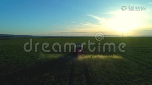 农用拖拉机耕田喷洒的鸟瞰图视频