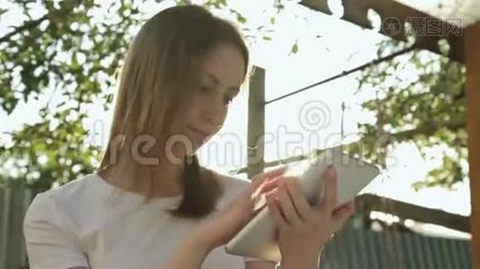 女人在日落时使用平板电脑视频
