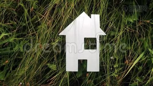 幸福家庭建设住宅理念.. 纸屋矗立在大自然的绿草中。 生活符号生活方式生态视频