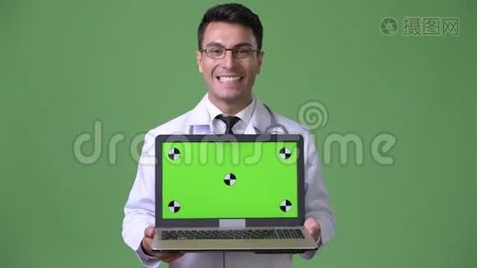 年轻英俊的西班牙男子医生，绿色背景视频