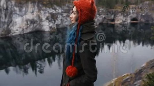 漂亮的女孩喜欢美丽的湖景从山上和良好的天气在卡雷利亚。 在岩石周围。视频