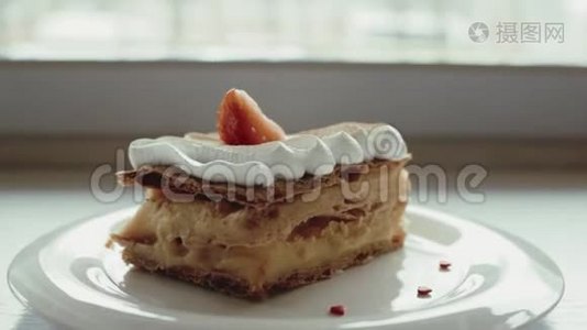 经典的法式甜点millefeuille放在木板上。 拿破仑蛋糕放在托盘或桌子上，上面有薄荷和一杯咖啡和鲜花视频