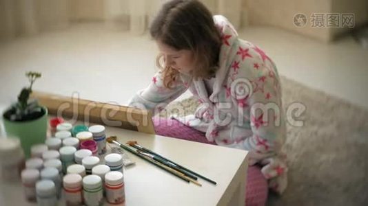 年轻的女画家在家坐在地板上创作绘画视频