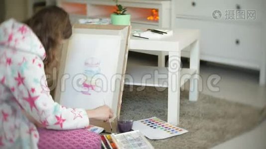 年轻的女画家在家坐在地板上创作绘画视频