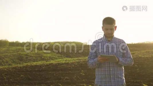 一位年轻漂亮的农民学生在田里干活，手里拿着拖拉机，手里拿着里面的肖像视频