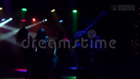 一群年轻人在黑暗中跳舞。 剪影视频