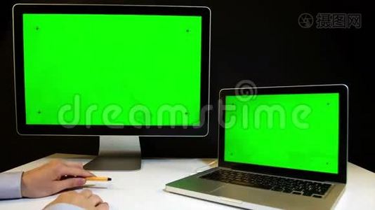 在笔记本电脑上工作并用绿色屏幕显示视频