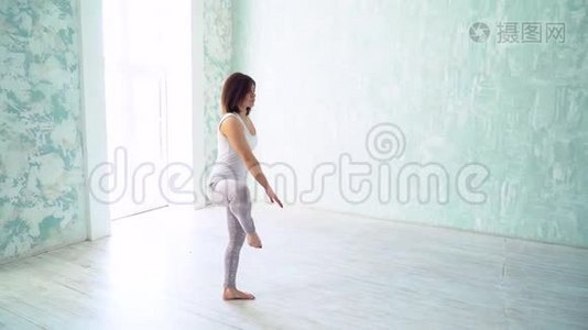 女人在室内工作室练习瑜伽。视频