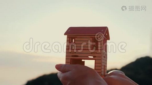 太阳落山时手里拿着纸房子的剪影。视频