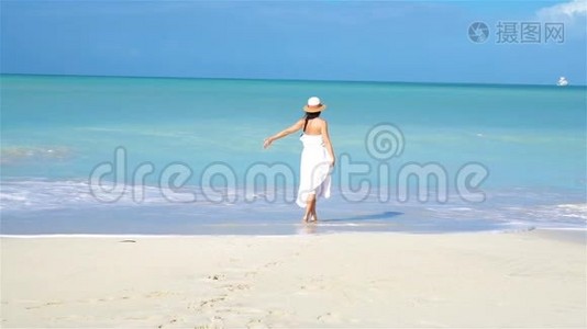 在白沙热带海滩上的年轻美女。视频