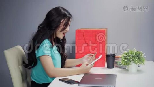 使用数码平板电脑及信用卡进行网上购物的妇女视频