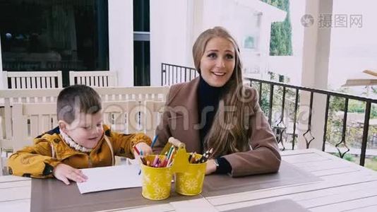 母亲和年幼的儿子在餐桌旁画画视频