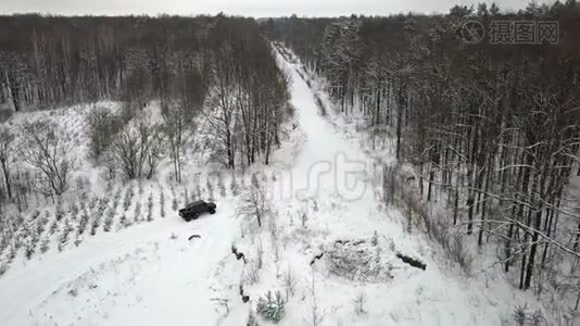 越野车6x6的鸟瞰图，在冬季森林的雪覆盖道路上行驶视频