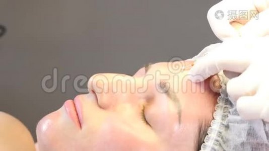 美容诊所。 美容师用手套在女性皮肤上进行面部老化注射。 一个女人得到美丽的脸视频