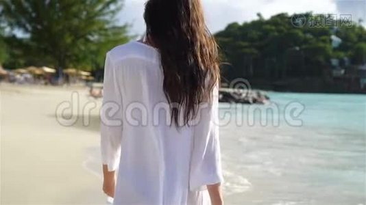 在白沙热带海滩上的年轻美女。视频