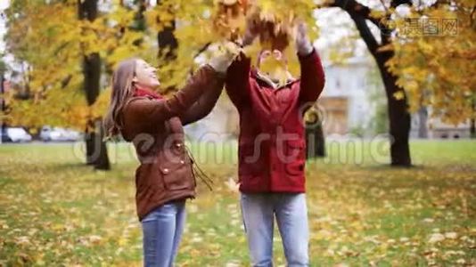 快乐的年轻夫妇在公园里扔秋叶视频
