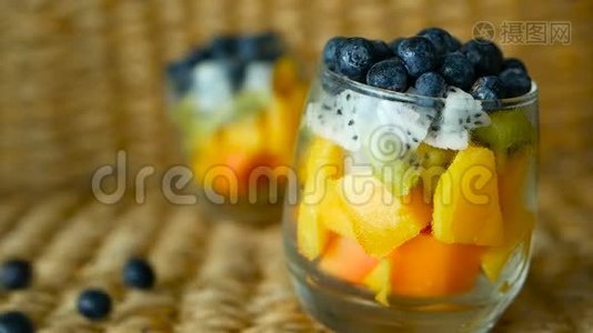 五颜六色的热带混合沙拉在罐子里。 玻璃碗中新鲜的各种生有机浆果和水果。 健康素食视频