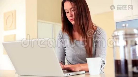 穿着笔记本电脑坐着喝咖啡的深黑色美女视频