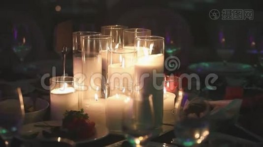 餐桌上的装饰蜡烛，桌子上的眼镜和圣诞蜡烛，带玻璃的白色蜡烛视频