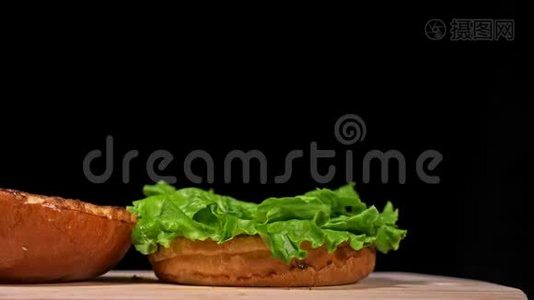 汉堡在黑色背景下用黑色食物手套做饭。 非常美味的空气面包和大理石牛肉。 餐厅视频