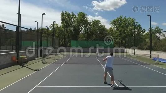 两个有魅力的人在球场上打网球视频