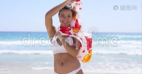 穿比基尼站在沙滩上的年轻女子视频
