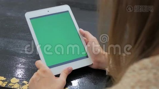 女人看着绿色屏幕的平板电脑视频