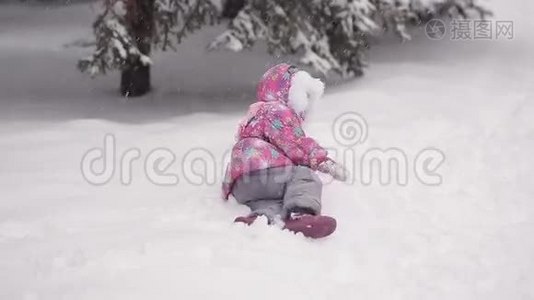 女孩在冬天的雪地里雕刻雪人。视频