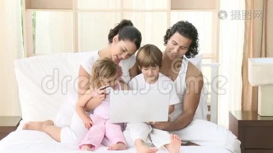 家人在床上用笔记本电脑视频