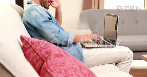 沙发上的帅哥用笔记本电脑视频
