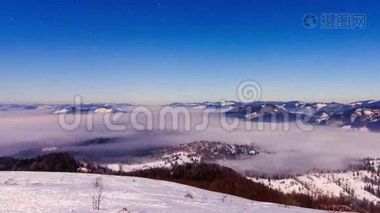 冬天，雾以星状的天空在山上移动视频