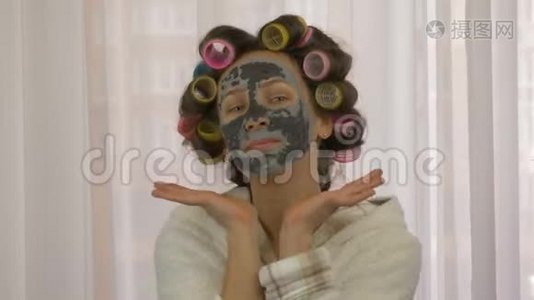 戴着黑色面罩的女人。 美容和美容的概念.. 女人脸上戴着粘土面具，闭上眼睛。 皮肤护理。 家庭主妇秀视频