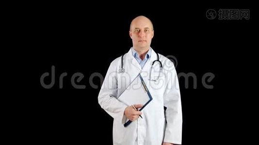肖像男医生穿着医用长袍和剪贴板在黑色背景。 穿白色外套的听诊器的医生视频