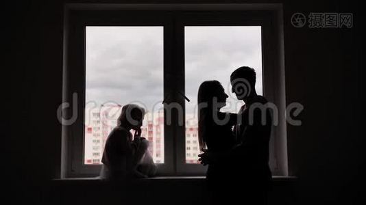 新公寓窗户背景上有孩子的恋人剪影。视频