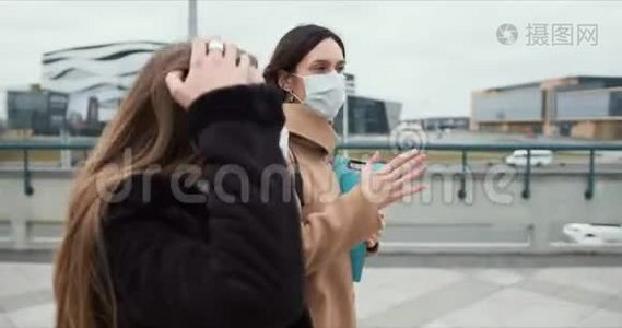 COVID-19流行病保健工作者。 两名白人女医生戴着医用口罩在空城街道上散步。视频