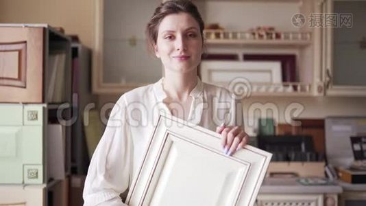 一位女卖家展示了厨房家具的例子。 一个年轻的小企业主看着摄像机视频