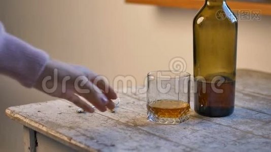 女人的手把钥匙放在桌子上，喝一杯威士忌，酒精成瘾的概念视频