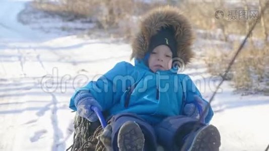 父母在冬天带着快乐的小男孩在雪橇上。 幼儿玩雪橇。 家庭圣诞节的户外乐趣视频