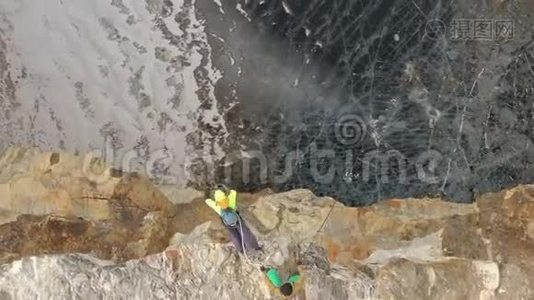 一个孤独的雄性登山者在雪山山顶上的鸟瞰。视频