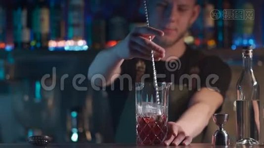 调酒师将经典的negroni鸡尾酒与朗姆酒和冰块混合视频