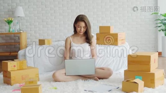 一位年轻的亚洲女性在家中闲逛，一位在家中使用笔记本电脑进行网上购物的女商人视频