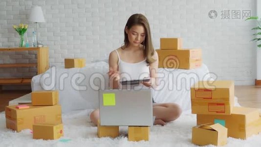 一位年轻的亚洲女性在家中闲逛，一位在家中使用笔记本电脑进行网上购物的女商人视频