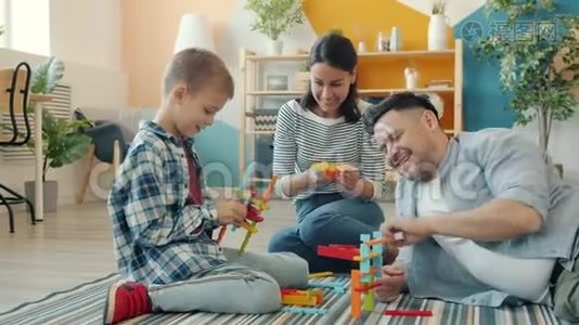幸福的家庭母亲，父亲和儿子在家玩建筑玩具，聊天视频