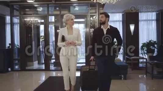 富有的年轻白种人夫妇来到豪华高级酒店的接待处。 有钱的顾客在前厅散步视频